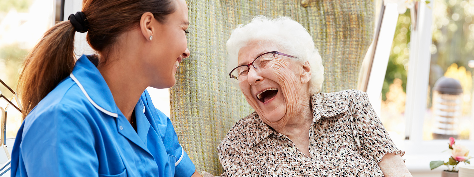 nurse-with-senior-woman-laughing nurse sitting and talking with senior woman