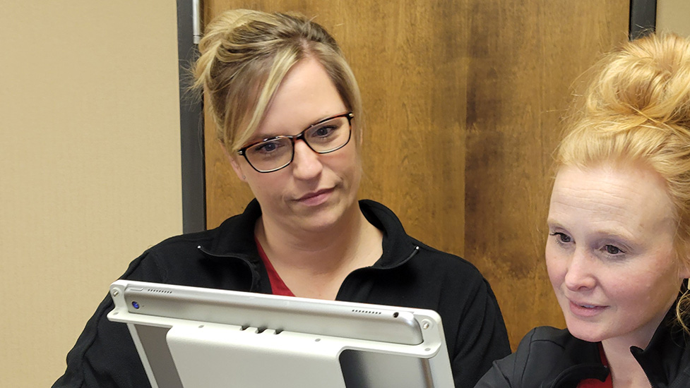 two nurses standing at nurses station